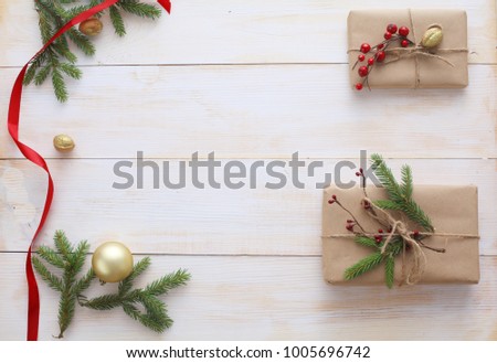 Christmas gift boxes and fir tree branch on wooden table, flat lay. ?hristmas background