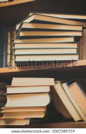 Old and used hardback books or text books seen from above. Books and reading are essential for self improvement, gaining knowledge and success in our careers, business and personal lives 