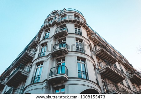 luxury corner building with curved facade in low angle view