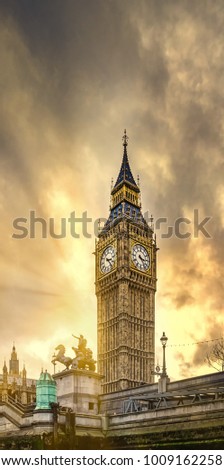 Low angle view of the Big Ben Tower of Parliament in Westminster at sunset with clouds and sun rays. London, United Kingdom.