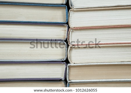 Chaotic stack of old books pastel colors, selective focus with copy space