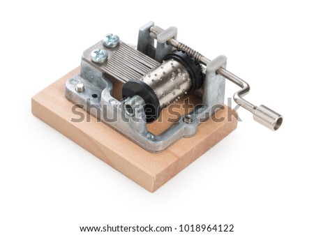 Vintage mechanical music box on a little wooden plank, isolated on white background.