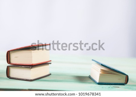 Pile of miniature books on wooden background. With copy space for your text