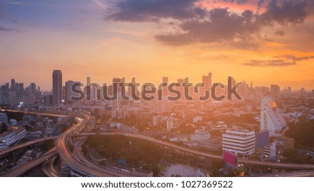Dramatic sunset sky over city business downtown and overpass interchange, Bangkok Thailand
