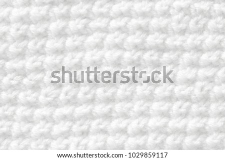 Knitting from woolen threads handmade. The texture is white, the background of the canvas is connected from the thread.