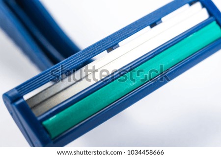 Man and woman body treatment of depilation with razor & skin care concept. Epilation hair removal. Closeup view with selective focus of disposable shaver isolated on abstract blurred white background