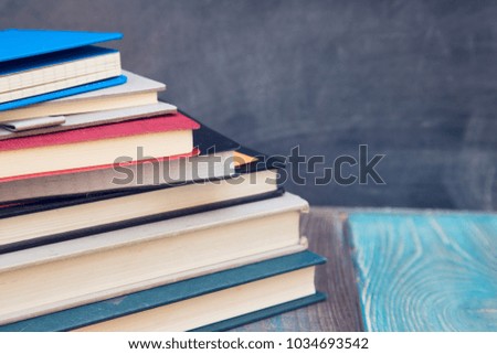 Geography lesson: Books on a black chalkboard, wooden table