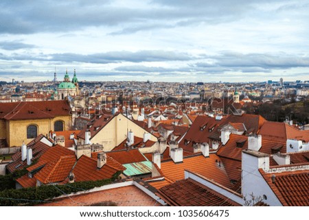 View of Prague over houses with red roofs. Amazing view from above at old historical quarter. Prague, Czech Republic. Prague is famous and popular travel destination city.