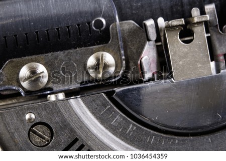 Typewriter shown in macro technology. A mechanical device for printing text. Light background.