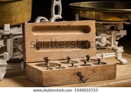Old brass weights for a kitchen scale in a wooden box