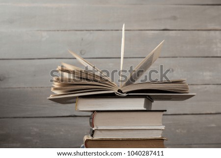 open book on a pile of books on wooden background