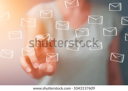 Businesswoman on blurred background holding and touching floating emails sketch