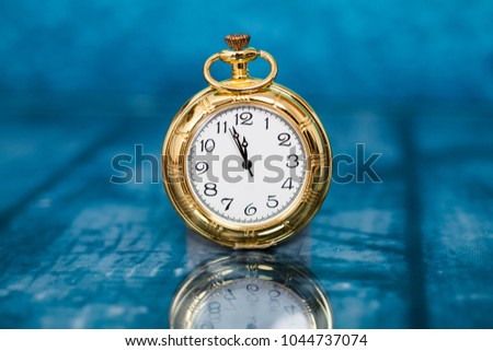 Vintage clock closed to midnight on blue wooden background