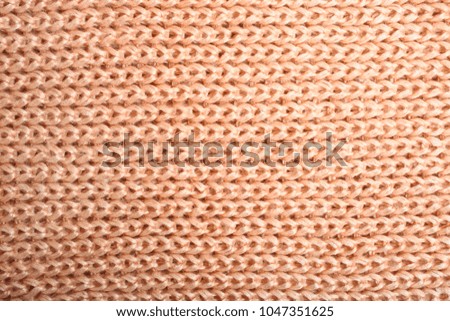 The texture of a beautiful beige knitted fabric. Background, copy space.