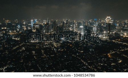 Drone photograph of metropolis Jakarta, Indonesia during the evening.