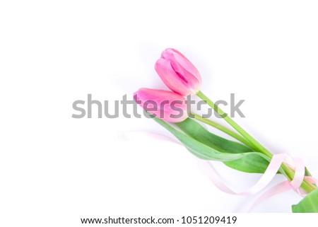 Spring pink tulips with ribbon on white background