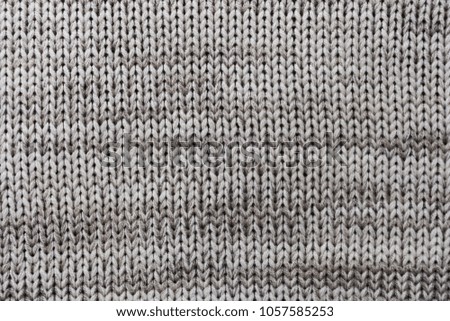 Close up of handmade knitted wool sweater/wool texture background with shades of grey