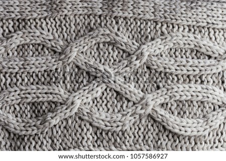 Close up of handmade knitted wool sweater with wavy pattern/wool texture background with shades of grey