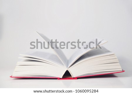 Open thick book on a table on a white background