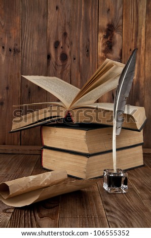 old books and pen on a wooden table