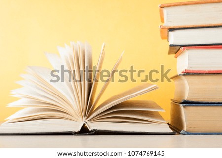 Open book and stack of books on wooden table. Education concept. Back to school.