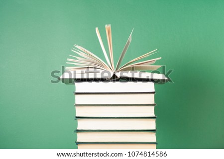 Open book on stack of books on wooden table. Education concept. Back to school.