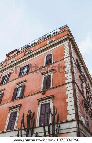 bottom view of old building on street of Rome on cloudy day, Italy