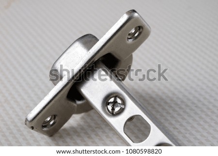 Assembly of hinges in a carpentry workshop. Joinery accessories in a carpentry workshop on a wooden table. Light background.