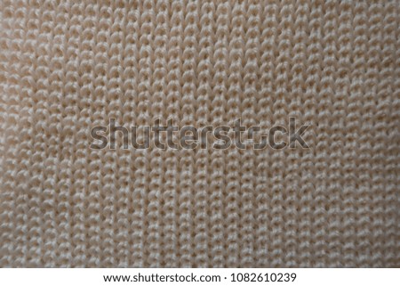 Beige handmade knitted fabric from above (ribbing pattern)