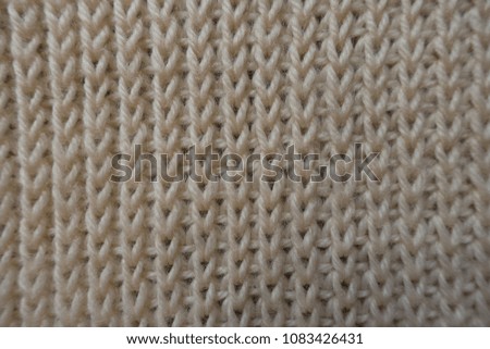 Cream handmade knitted fabric from above (ribbing pattern)