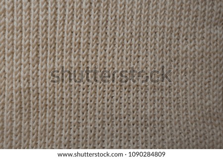 Ribbing pattern on handmade beige knitted fabric
