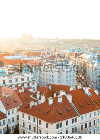 Sunset in Prague, Czech Republic. Aerial view at the scenic cityscape with red roofs of old town and Hradcany Castle on horizon