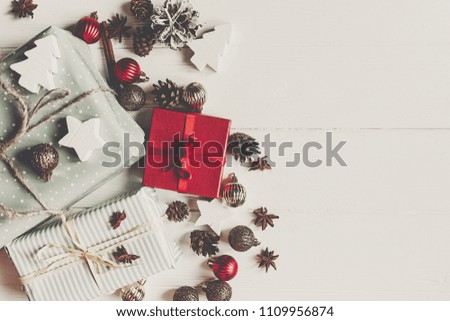 wrapped present boxes with ornaments pine cones anise on white wooden background top view, space for text. christmas flat lay. seasonal greetings card. happy holidays.
