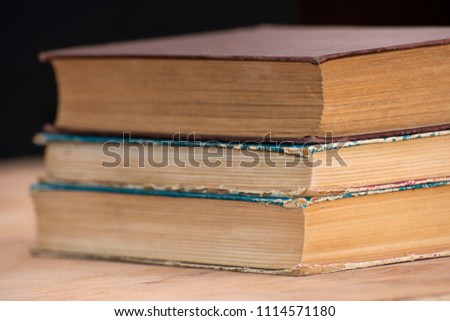 A stack of old books lie on top of each other on the table. Library, education. Empty place for text.
