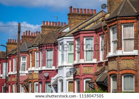 A row of typical British terraced houses around Kensal Rise in London with a telephone pole