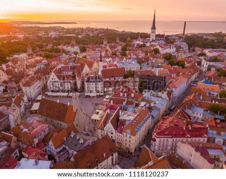 Beautiful orange sunset over old town of Tallinn in Estonia with the Raekoja plats, castle and old medieval towers. 