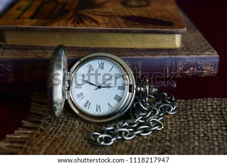 Old pocket watch and books on the table