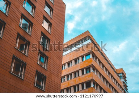red and orange apartment or office buildings in a row on a summer day