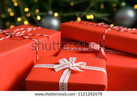 Beautiful gift boxes and blurred Christmas tree on background