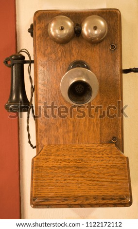 Vintage, ancient telephone made of dark brown wood.
