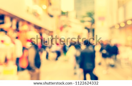 Abstract Blurred image of People walking at footpath on day time with bokeh for background usage .(vintage tone)