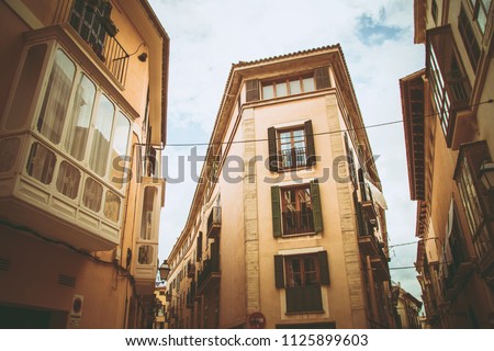 A cozy street with old building facades with a balcony, Palma de Mallorca, Spain