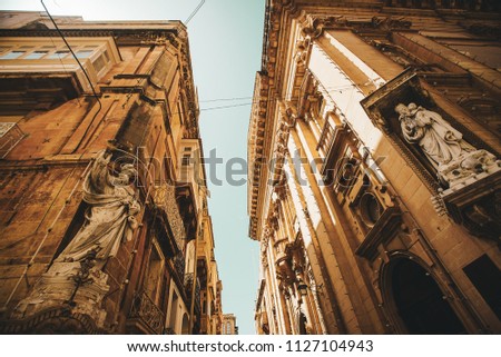 Traditional Maltese street with corners of houses, decorated with statues of saint in Valletta, Capital city of Malta. Building facade