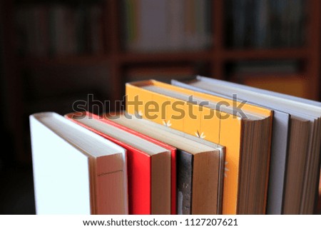 Books stacked in the library have bookshelves in the background selective focus and shallow depth of field