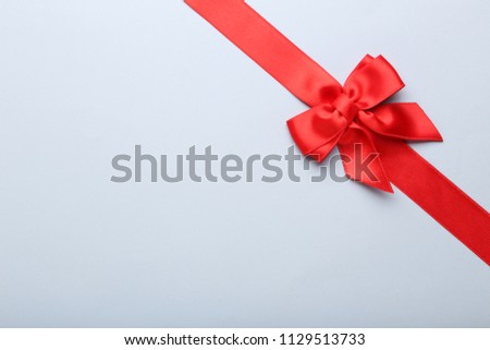 Red bow with ribbon on grey background