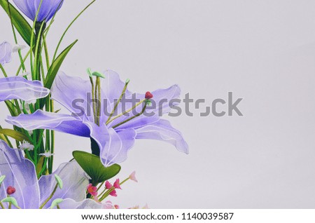 Purple artificial flowers in beautiful small pot on white background