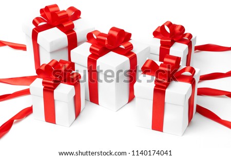 White gift box with red ribbon bow and christmas balls around, isolated on white background