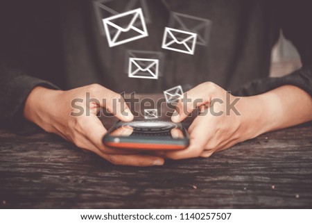 Woman hand using smartphone to send and recieve email for business on bokeh vintage color tone background.