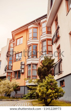 New multi-storey residential building. Modern house dyed in red and orange colors