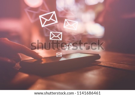 Woman hand using smartphone to send and recieve email for business on bokeh vintage color tone background. Technology freedom life style concept.